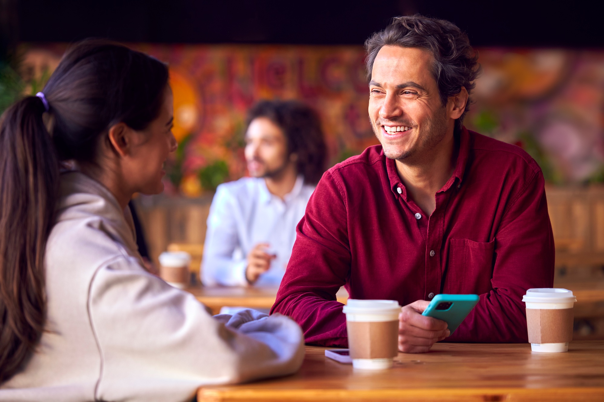 Couple On Date Meeting And Talking At Table In Coffee Shop