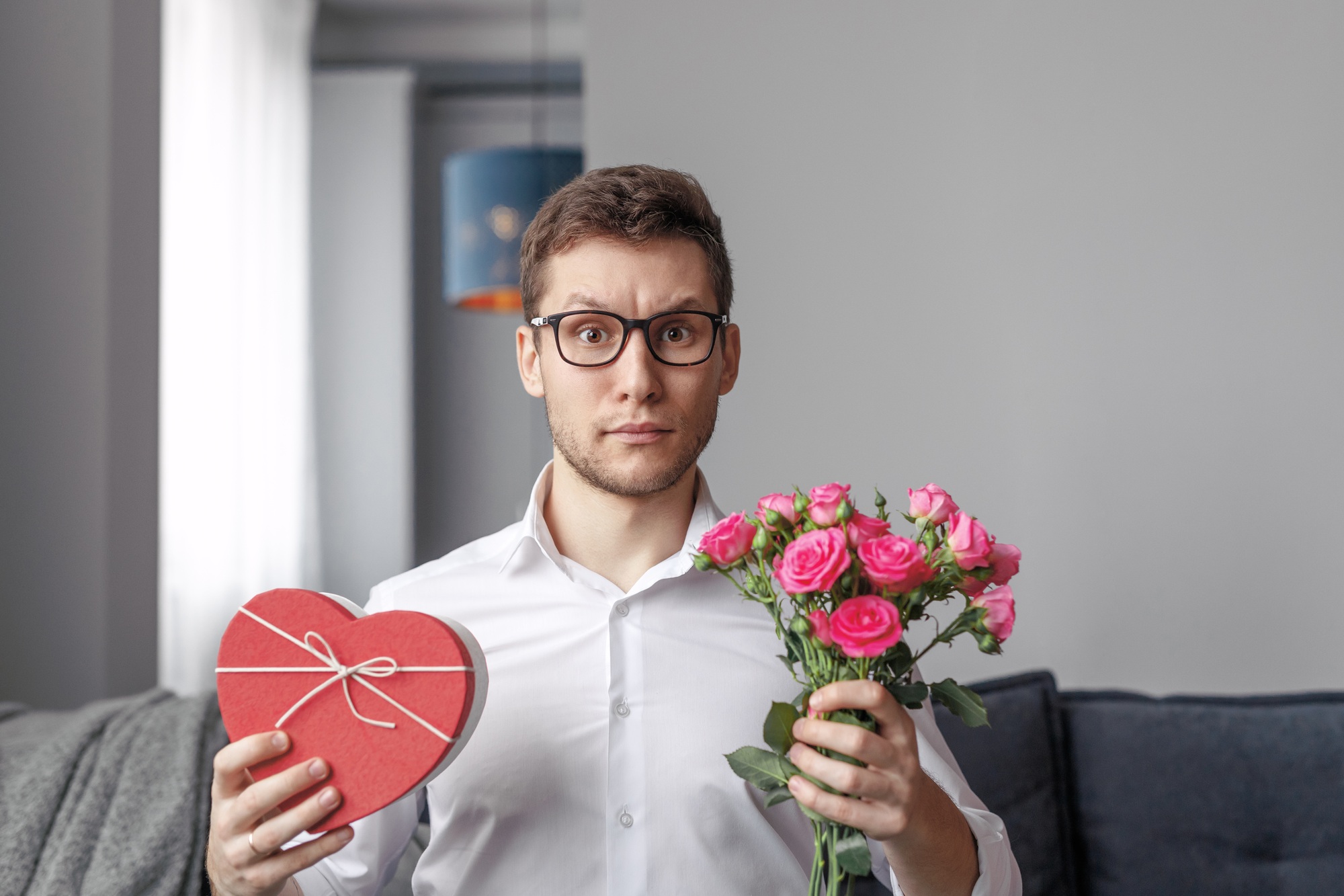 Shy man with Valentines Day present and flowers